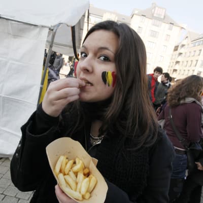 En belgisk kvinna äter pommes frites under en demonstration mot de misslyckade regeringsförhandlingarna år 2011.