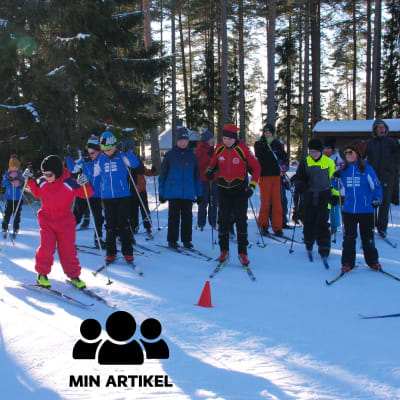 Flera personer, främst unga, på längdskidor i strålande vinterväder.