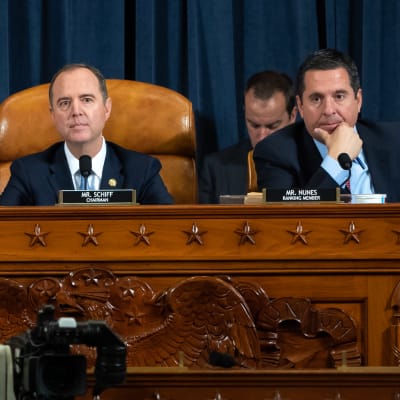 Ordföranden för representanthuset underrättelseutskott, demokraten Adan Schiff  i mitten och republikanernas ledande medlem i utskottet Devin Nunes (andra från höger) under de tv-sända förhören  den 13 november 2019.