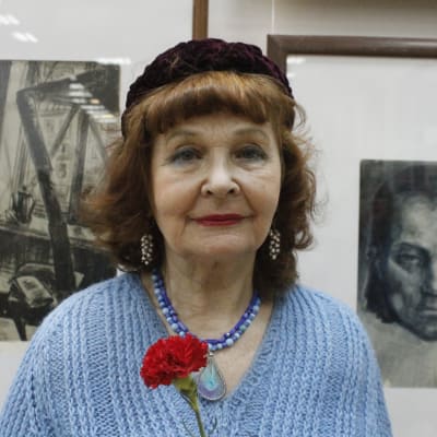 Margarita Izotova står framför Marttila-tavlor. Enligt Margarita Izotova skapar de sköna verken en stark själ. 