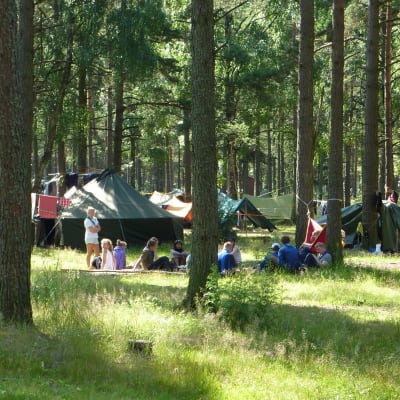 Tält och ungdomar på scoutläger i Syndalen sommaren 2009.