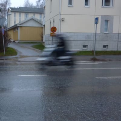 Mopedist i regnväder.