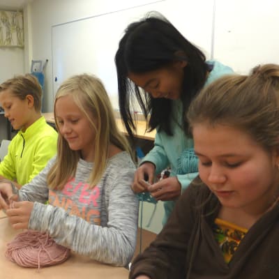 Victoria Alopaeus, Edvin Karell, Alma Krogell, Annie Keskinen och Ronja Heinström handarbetar vid ett bord i Sjundeå svenska skola.