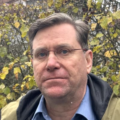 Jari Nummikoski seisoo ulkona ja katsoo kameraan vakavana.