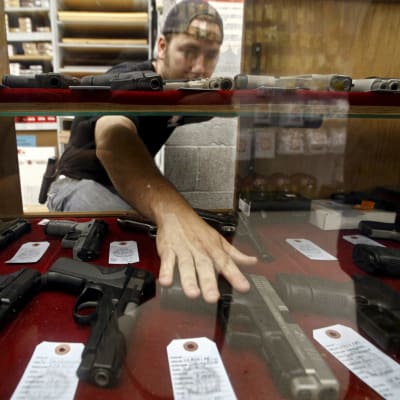 Man sträcker sig efter en pistol i en vapenaffär i Kansas