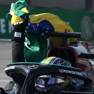 Lewis Hamilton firar med den brasilianska flaggan.