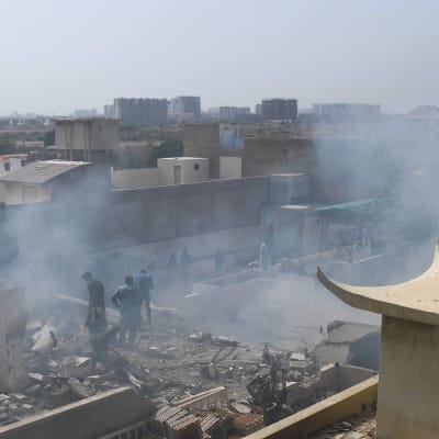 Rök och eventuellt damm i luften efter en flygkrasch i ett bostadsområde i Karachi den 22 maj. 