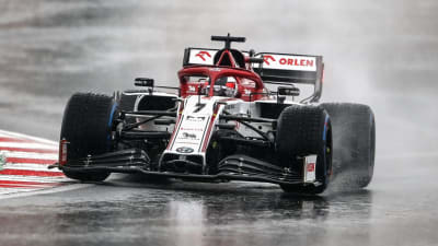 Kimi Räikkönen kör i regn i en kurva.