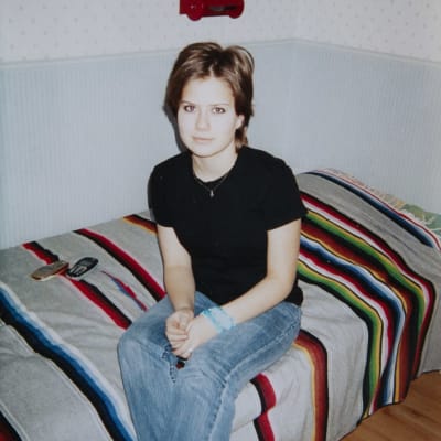 14-åriga Madeleine Roos sitter på sin säng.
