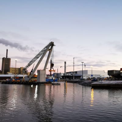 En pontonkran lyfter betongelement på plats i bassängen i Vasa hamn.