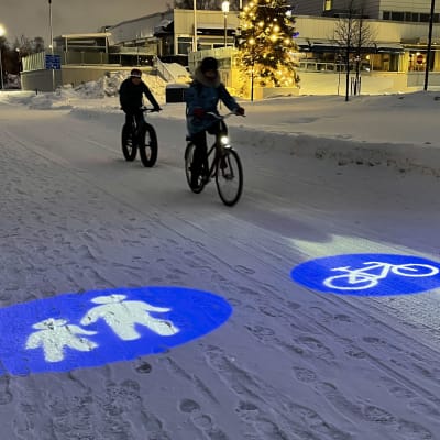 Maahan projisoitavat liikennemerkit Oulun pyöräbaanalla.