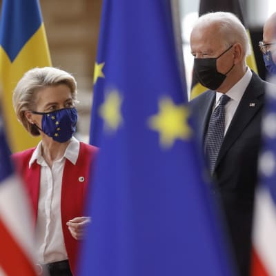 Ursula von der Leyen till vänster och Joe Biden till höger. I förgrunden flaggor.