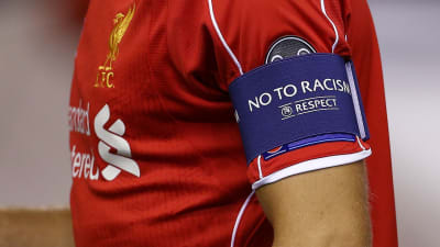 Fotbollsspelare med armbindel med "No to racism". 