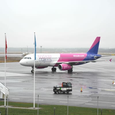 Wizz airs flyg i vitt, rosa och blått på landningsbanan.