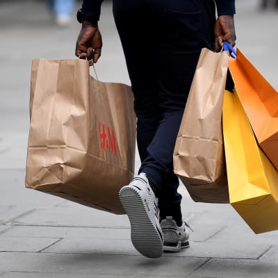 Person går med shoppingpåsar i händerna.