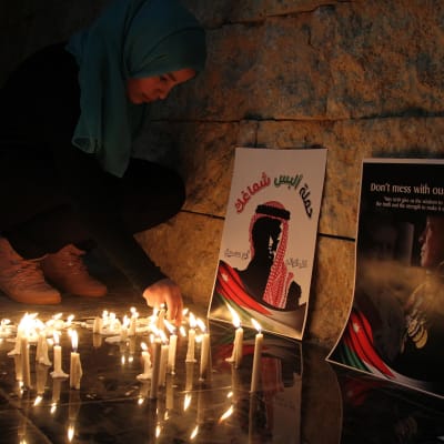Jordanialainen nainen sytytti kynttilän terroristijärjestö Isisin murhaaman lentäjän muistoksi Ammanissa helmikuussa 2015.