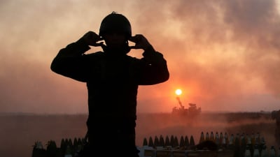 Soldat i ljuset av eldgivning i Gaza