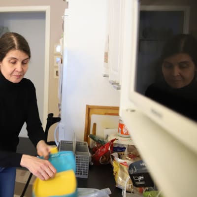 Joensuulainen Satu Lamminsalo tyhjentää puhtaita astioita tiskikoneesta.