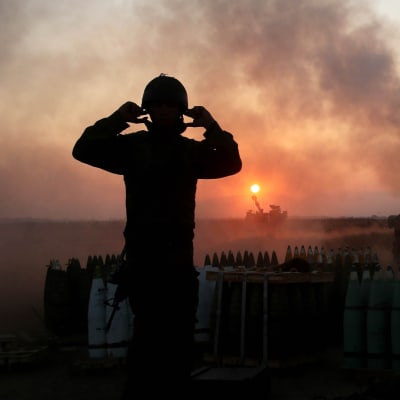 Soldat i ljuset av eldgivning i Gaza