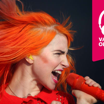 Hayley Williams sjunger i en mikrofon som hon hålleri handen.