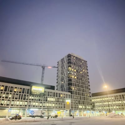 Kuopion vuonna 2021 valmistuneen matkakeskuksen uudet rakennukset ja tilat talvella valaistuna iltahämärässä.