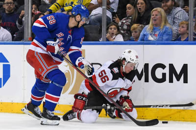 Erik Haula står på knä och försöker vinna puck.