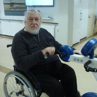 En äldre man sitter i rullstol.