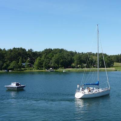En tömningsstation för septiktankar flyter på vattnet. Bredvid syns en segelbåt. 