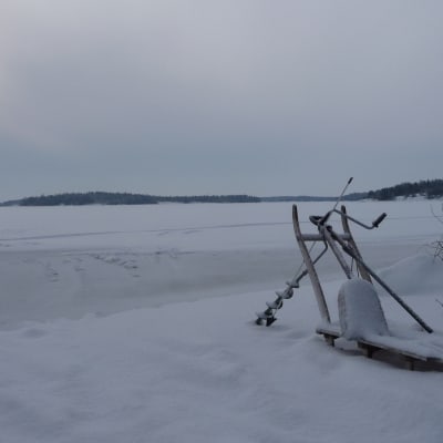Vinterlandskap och redskap för pilkfiske
