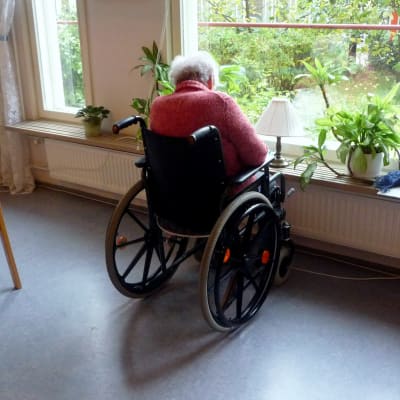 Äldre person i rullstol.