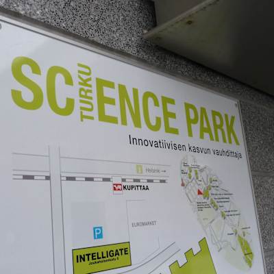 Närbild av Science Parks grönvita skylt på husväggen.