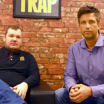 Antti Nordberg och Tommy Westlin sitter i en soffa vid sin arbetsplats.