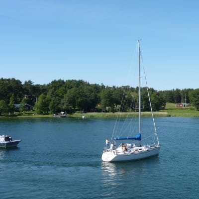 En tömningsstation för septiktankar flyter på vattnet. Bredvid syns en segelbåt. 