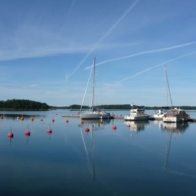 Stiltje vid en hamn med några båtar förtöjda.