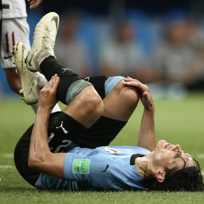 Edinson Cavani makaa maassa tuskaisena.