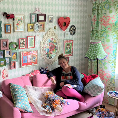Tiina Kärkäs-Sund istuu vaaleanpunaisen sohvan nurkassa lempipaikassaan.
