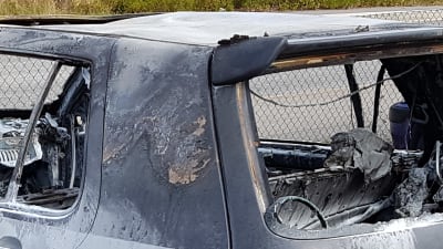 En del av en bränd grå personbil.