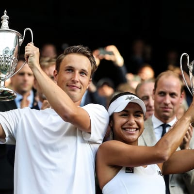 Henri Kontinen och Heather Watson lyfter segerpokalerna i Wimbledon.