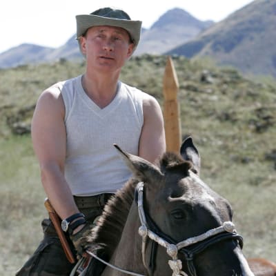 Vladimir Putin sitter på en häst i ett ärmlöst linne.