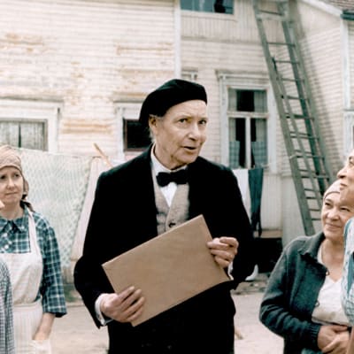 Valokuvaaja Hurme (Toivo Mäkelä) naurattaa pihan naisia elokuvassa Aika hyvä ihmiseksi (1977).