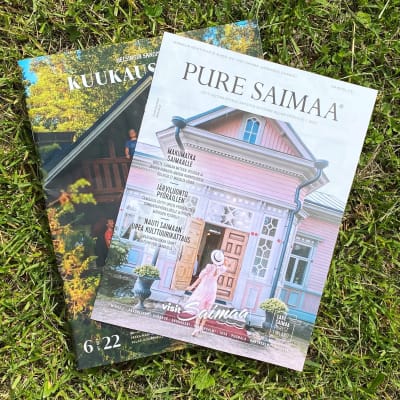Helsingin Sanomien Kuukausiliite ja Pure Saimaa-liite nurmikolla. 