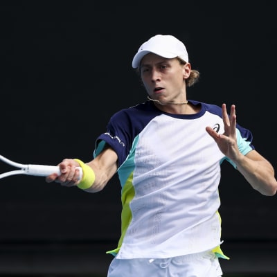Emil Ruusuvuori slår en tennisboll med sin racket.