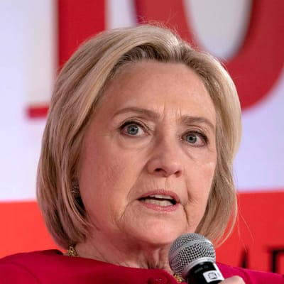 Porträtt på Hillary Clinton som talar i en mikrofon.
