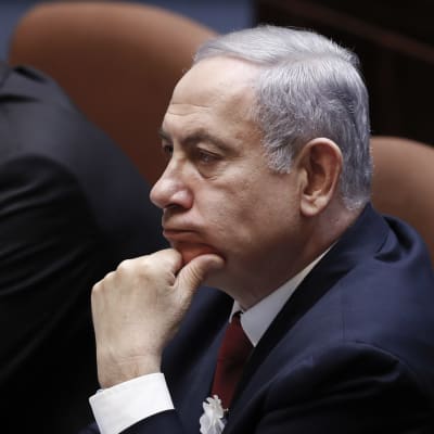 Benjamin Netanyahu sitter med handen mot hakan.