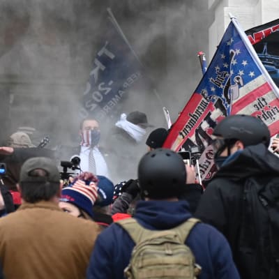 Trump-anhängare i ett moln av tårgas utanför Capitolium onsdagen den 6 januari. 