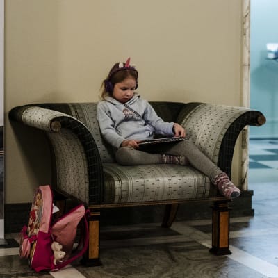 5-vuotias Minja Västinen katseli Netflixiä tabletilta eduskunnan valtiosalissa