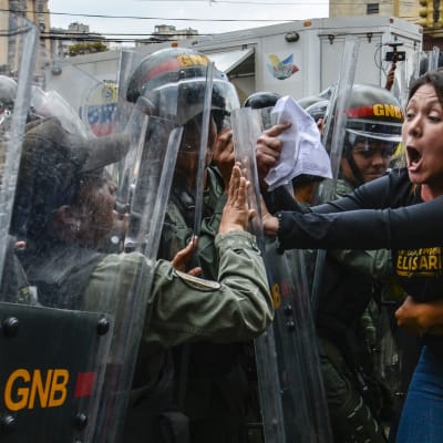 Den oppositionella kongressledamoten Amelia Belisario drabbar samman med kravallpolis utanför högsta domstolen i Caracas 30.3.2017