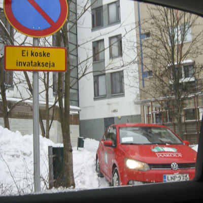 Privat foto av Anita Andersson på en bil från husets servicebolag som parkerat där hennes taxi ska stanna.
