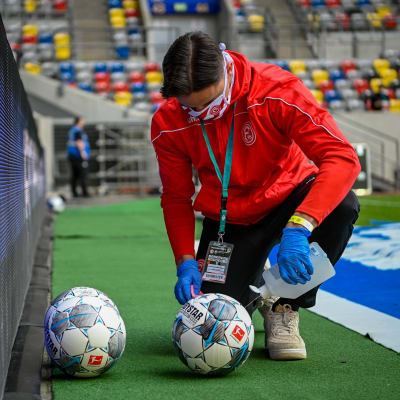 En bollkalle ser till att bollarna i matchen mellan Fortuna Düsseldorf och Paderborn hålls rena.
