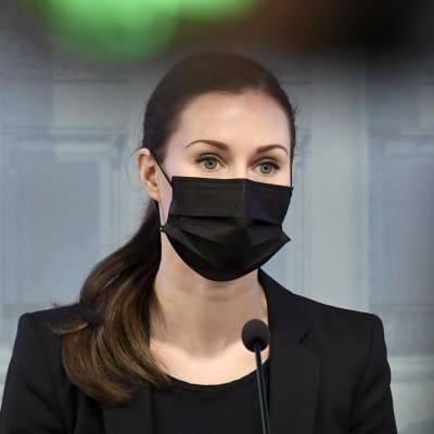 Sanna Marin håller presskonferens 9.4.2021. Hon bär ett svart munskydd.